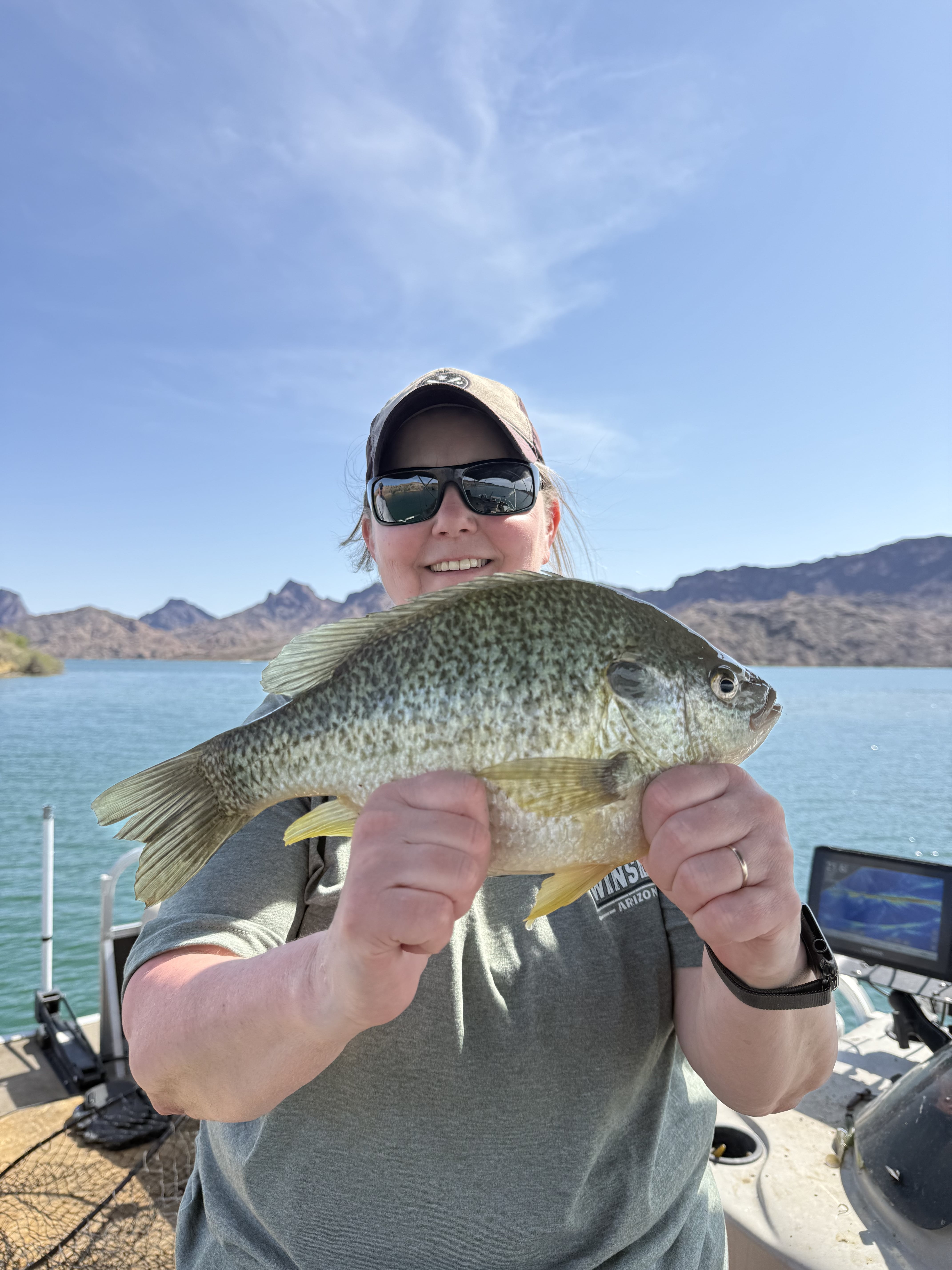 Angler holding a redear sunfish with mountains in background