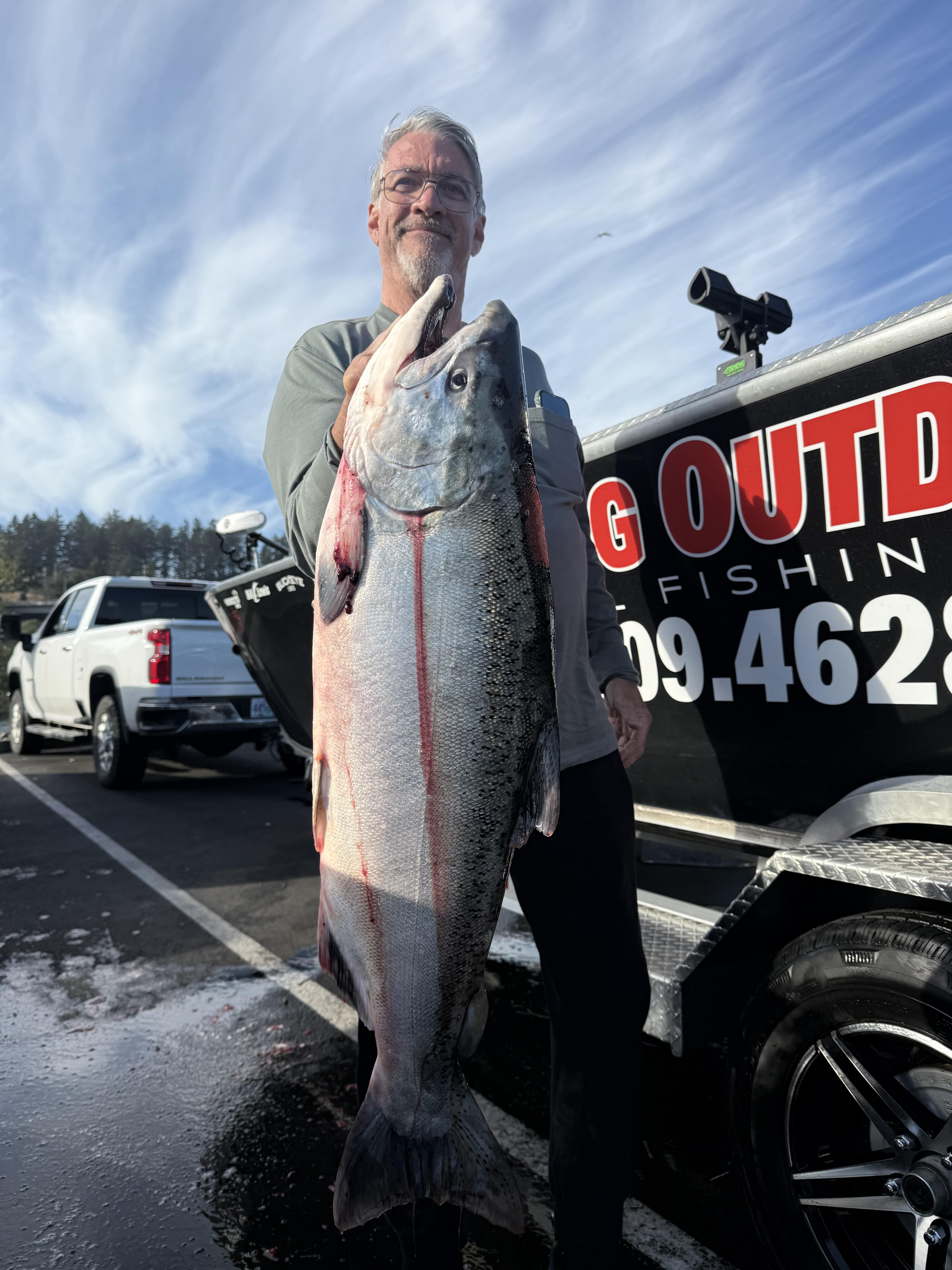 Striped bass held horizontally for a photo on the boat